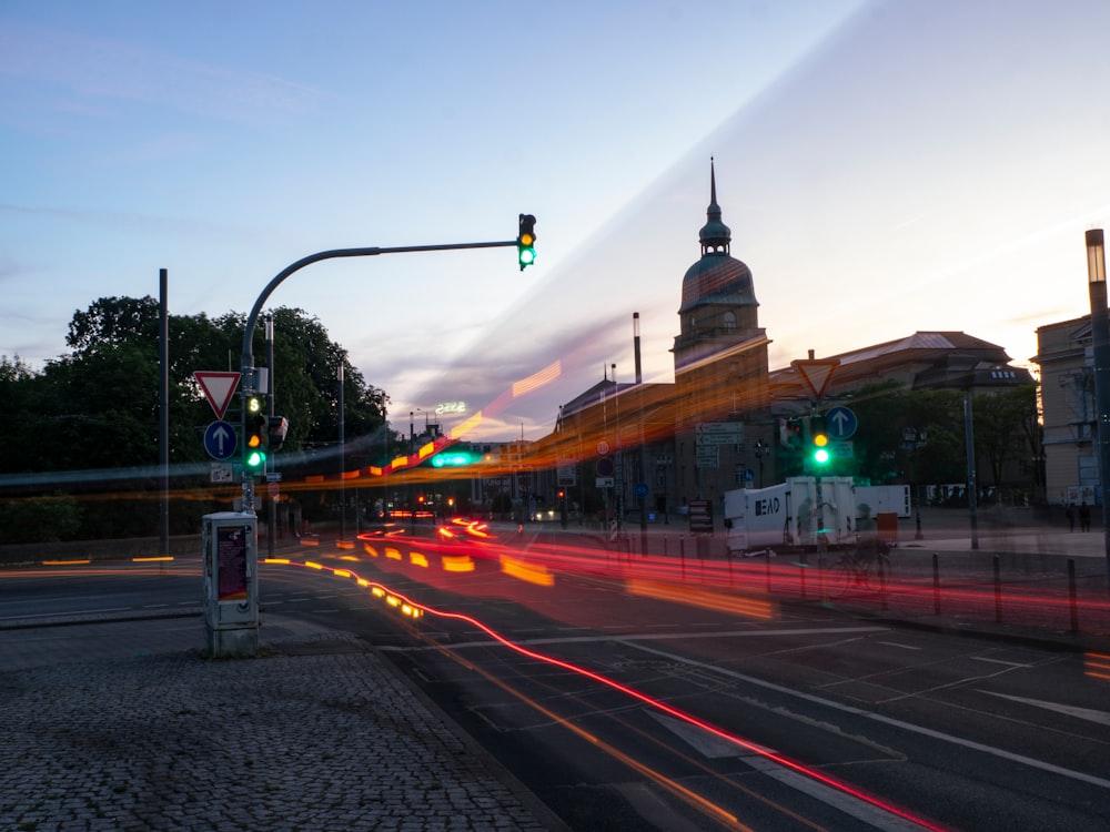 a city street with traffic lights and a clock tower in the background