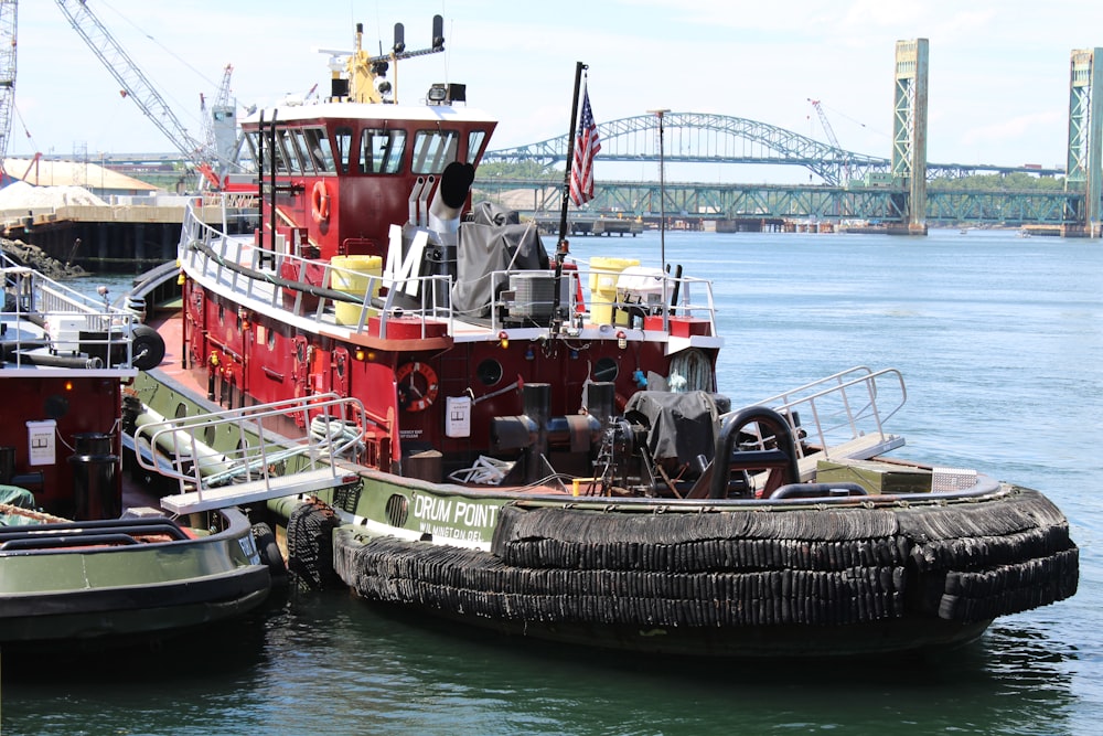 a tug boat sitting in the water next to another boat