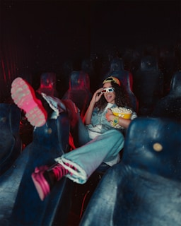A person enjoying a movie night with popcorn and drinks.