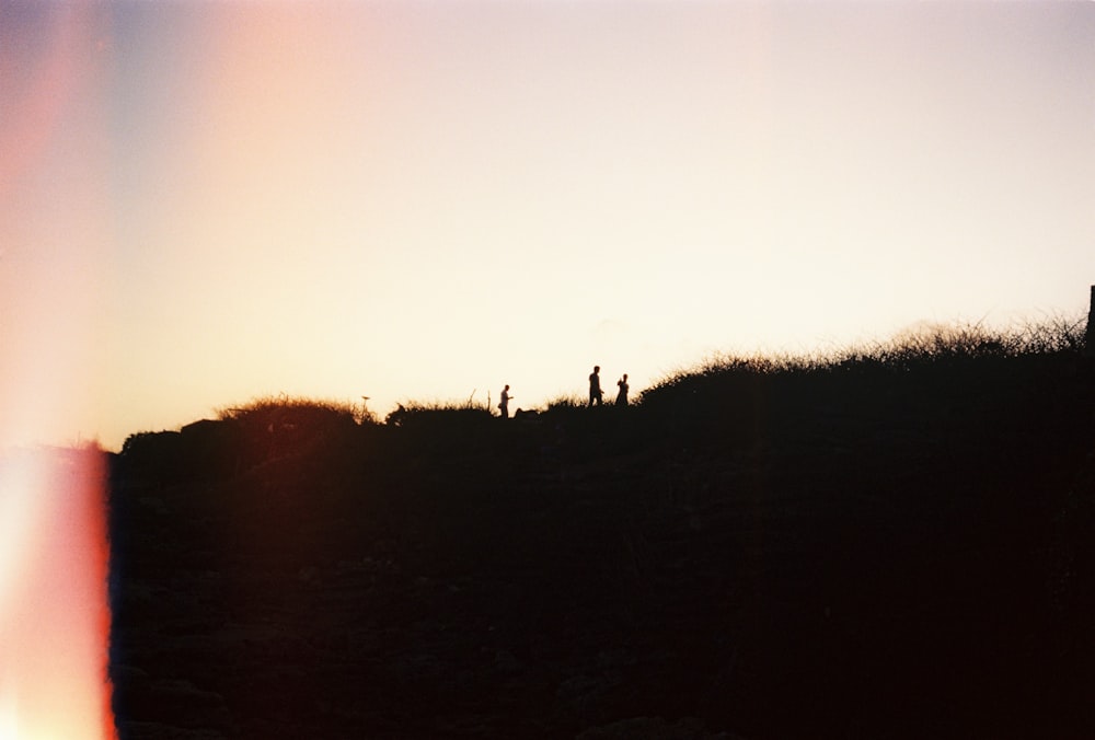 a group of people standing on top of a hill