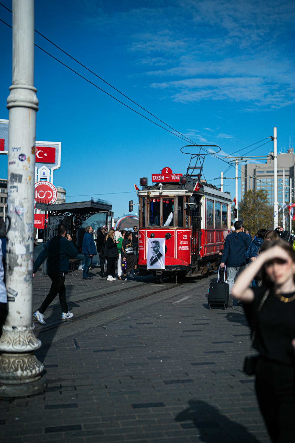 a group of people walking down a street next to a trolley