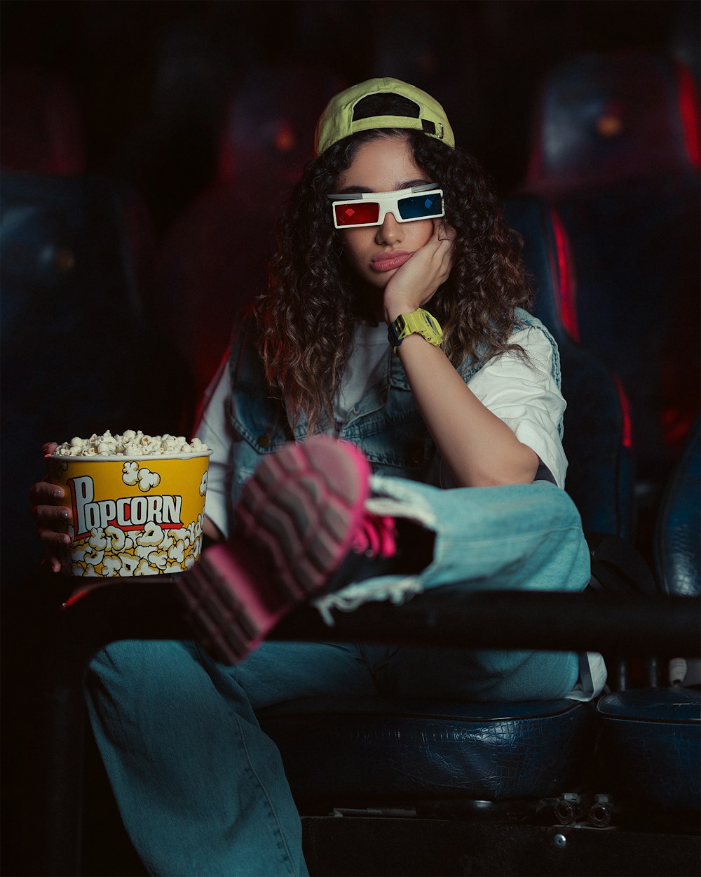 a woman wearing 3d glasses and holding a popcorn box