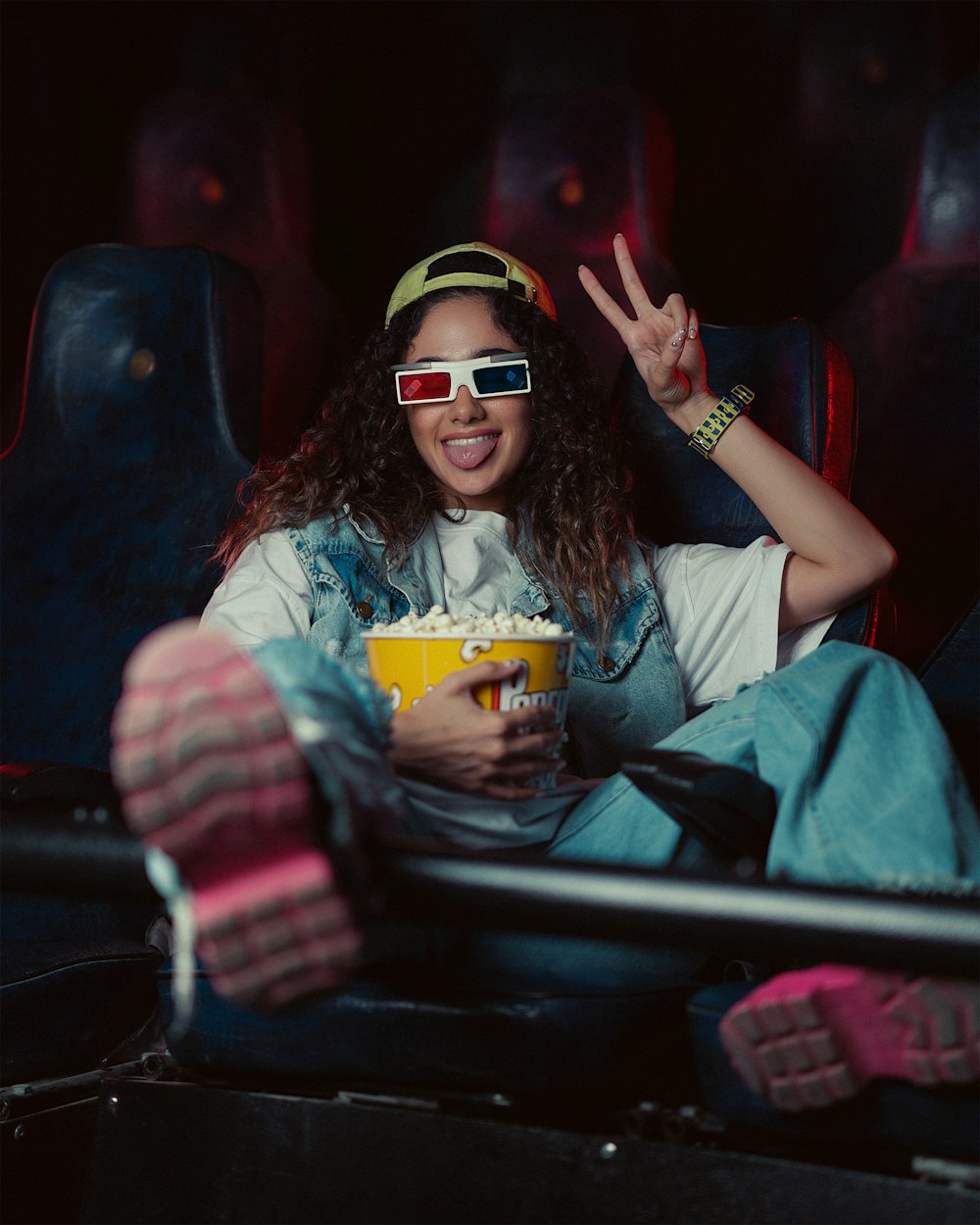 a woman wearing 3d glasses sitting in a movie theater