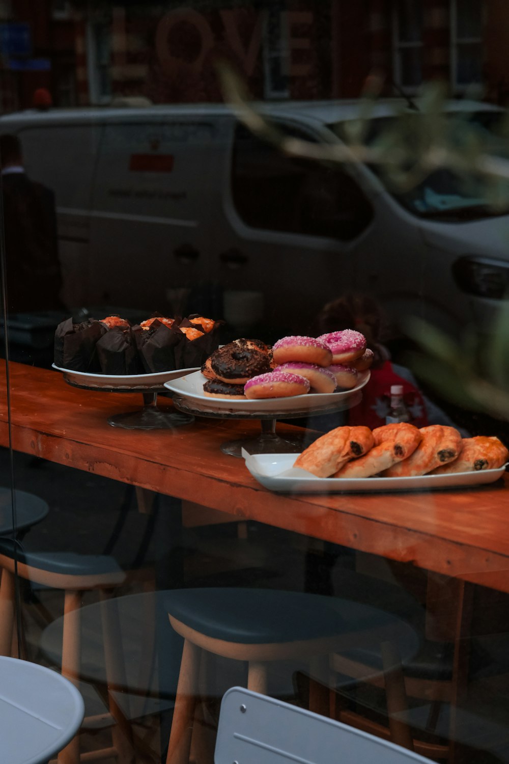 a wooden table topped with plates of donuts