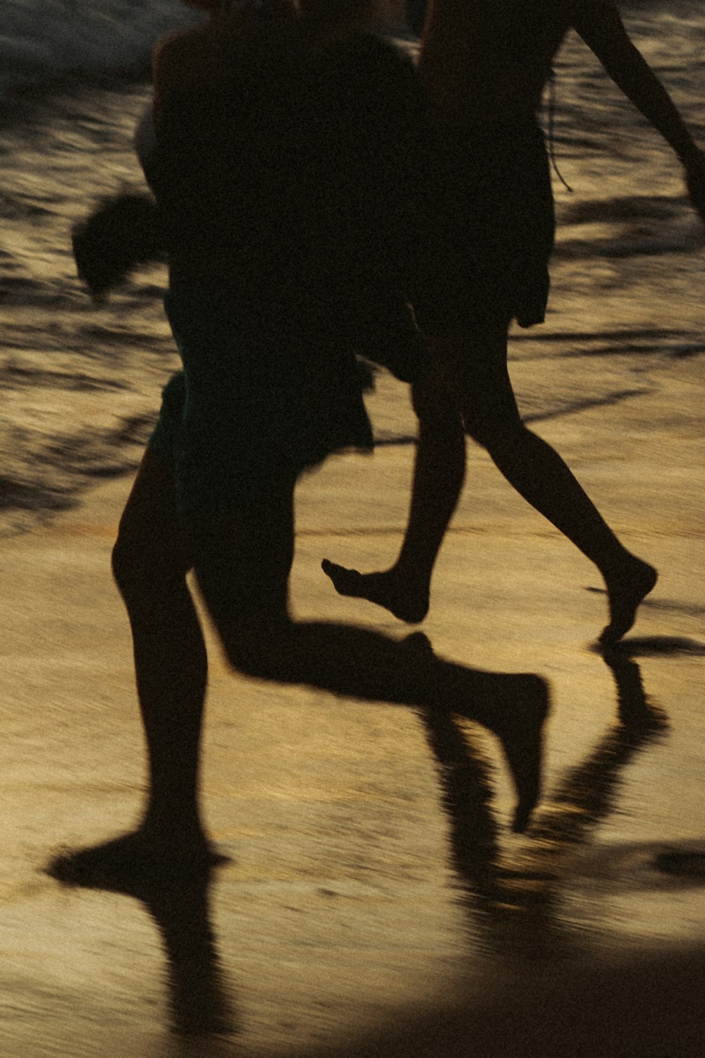 a couple of people that are running on a beach