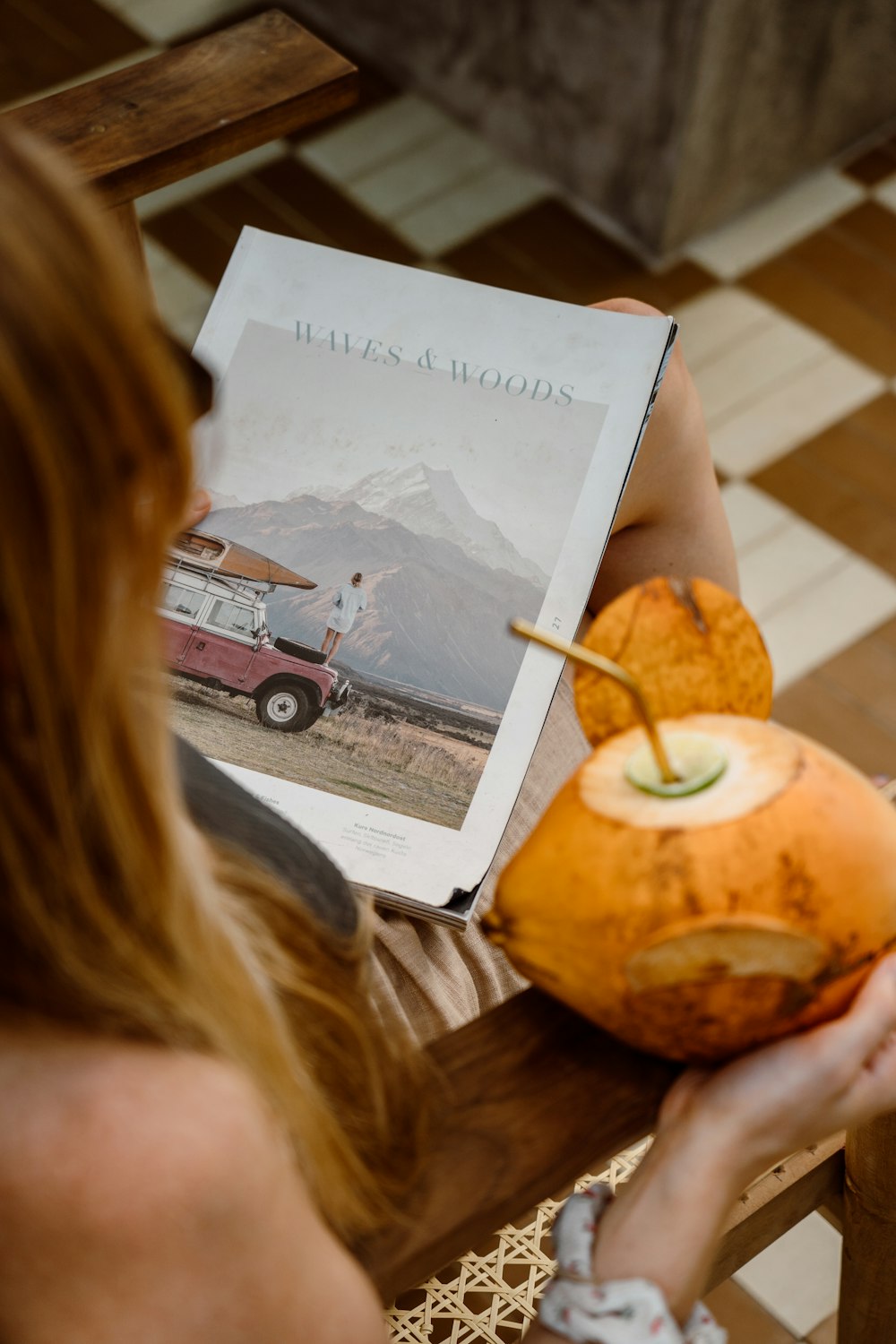 a woman holding a coconut drink and a book