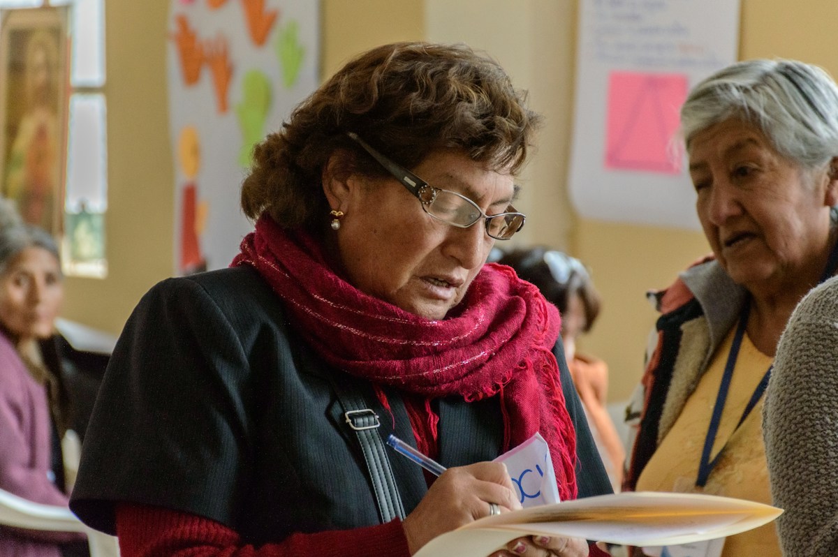A group of women reviewing a volunteer sign-up sheet for the Salvation Army's Christmas volunteer operation.