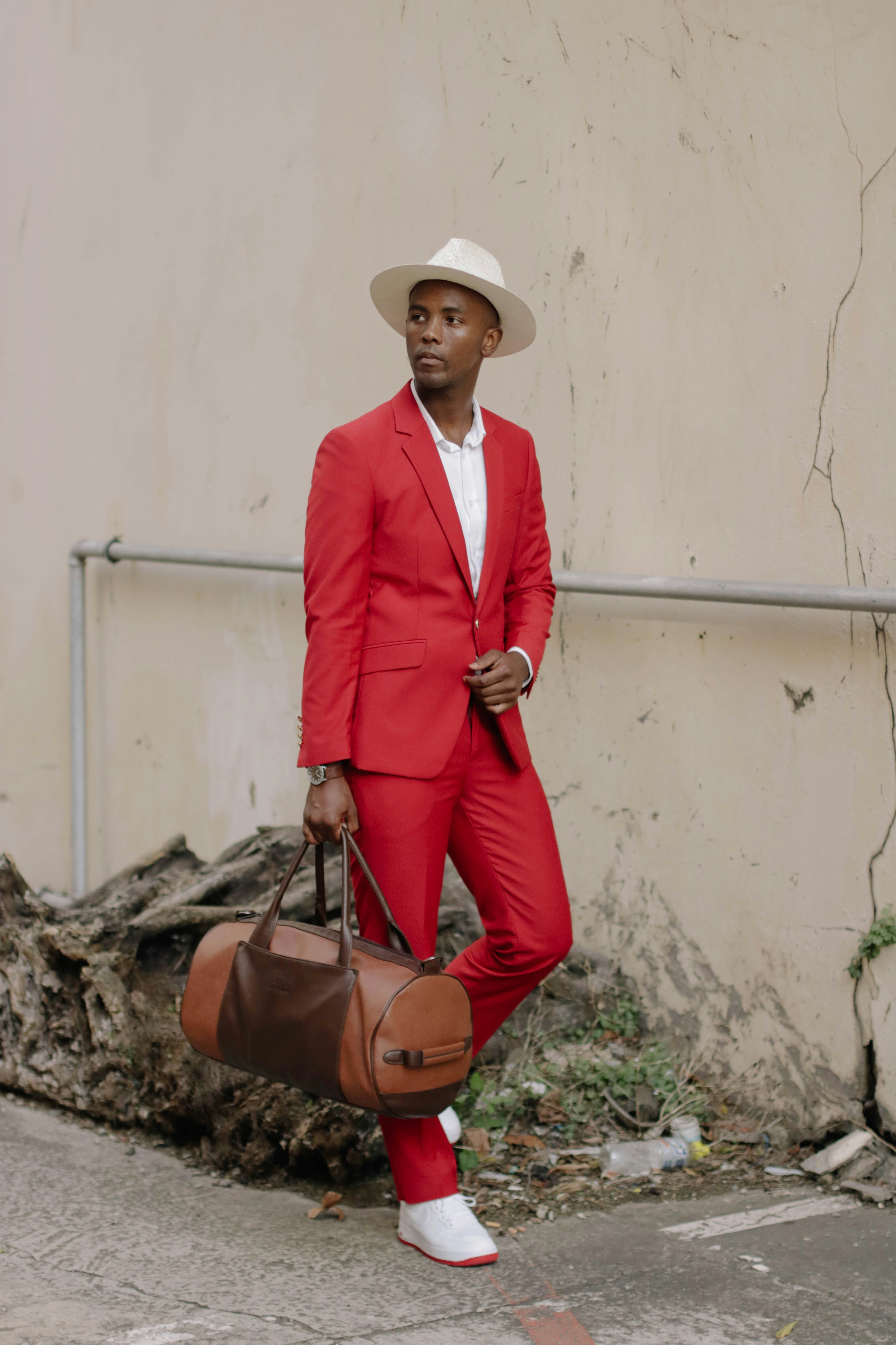 a man in a red suit holding a brown bag