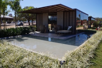 A modern pavilion with geometric shapes and a seamless indoor-outdoor flow surrounded by greenery.