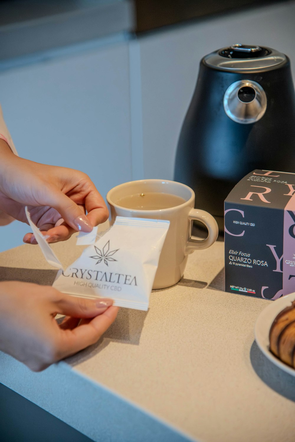 a person is putting a bag of coffee in a cup