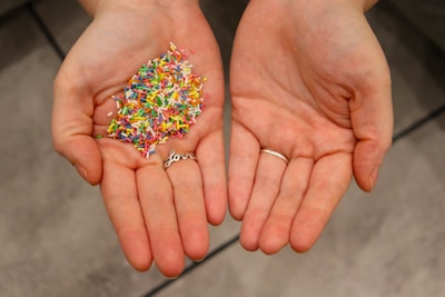 a person holding a handful of sprinkles in their hands