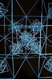 An abstract 3D wireframe of a complex digital structure illuminated with deep space blue and neon cyan highlights.