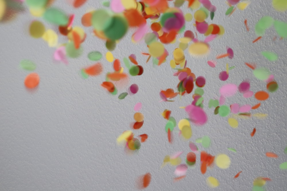 a bunch of colorful confetti falling from a ceiling