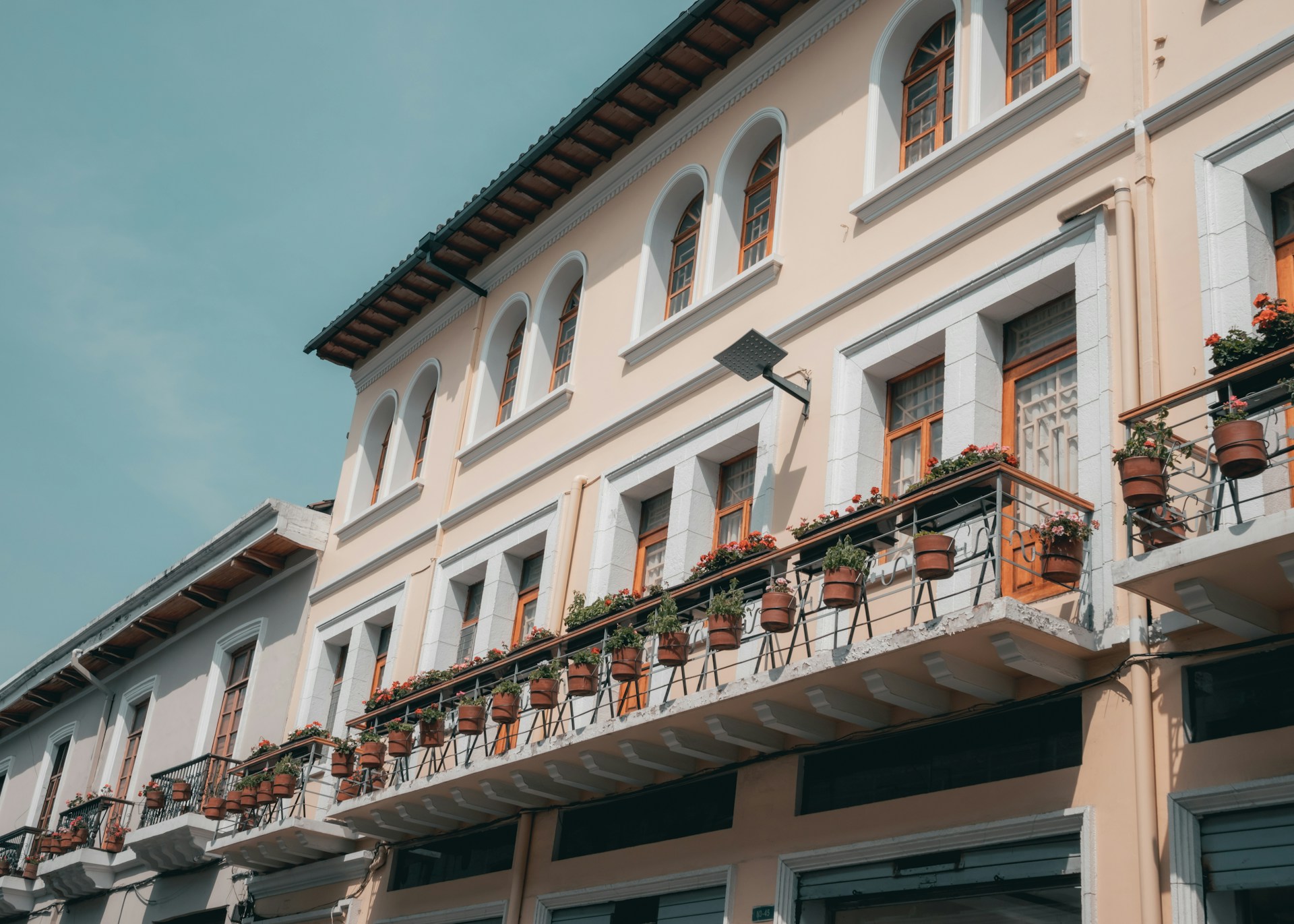 a building with a lot of potted plants on the balconies