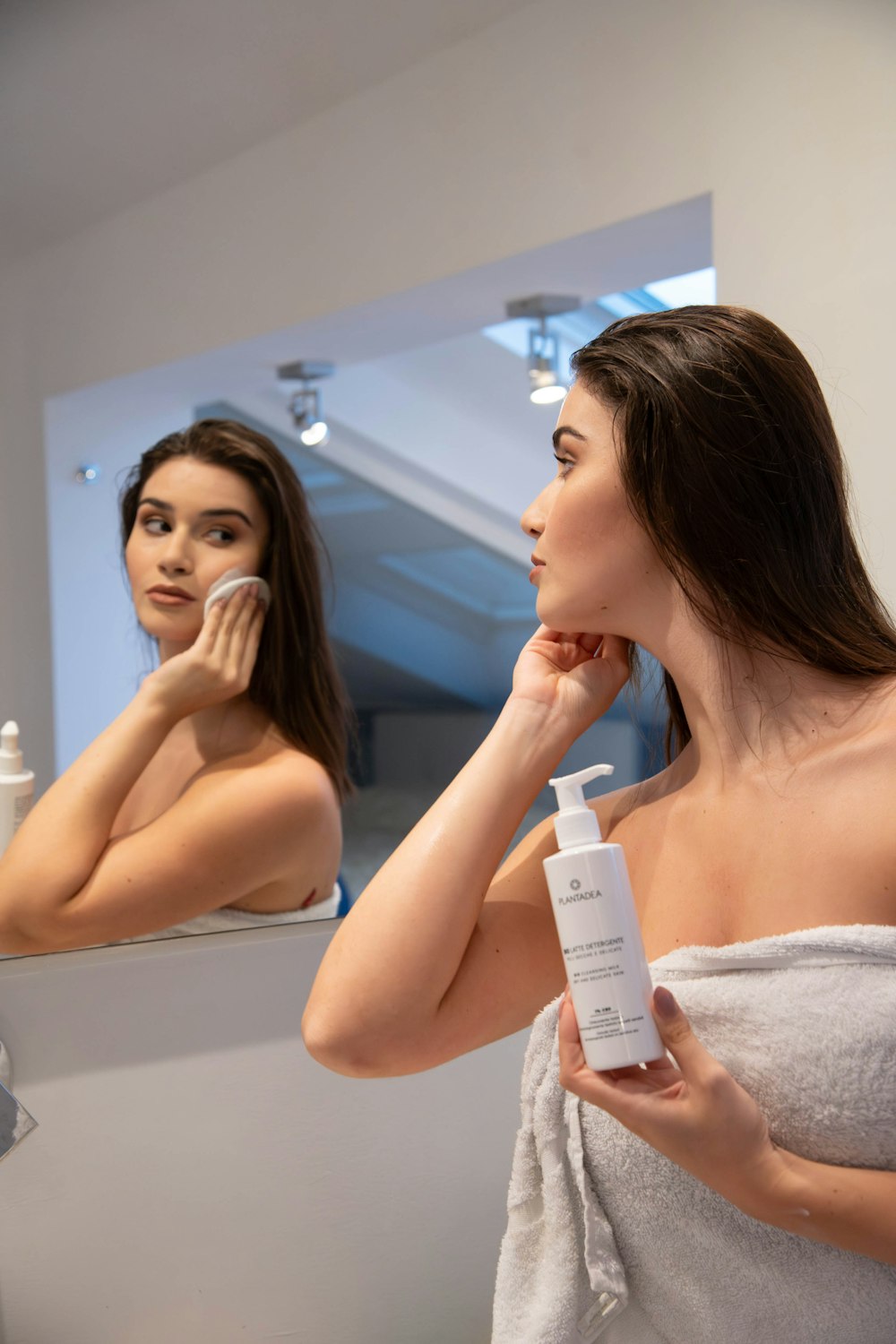 a woman brushing her teeth in front of a mirror