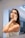 Close-up of a person applying hair care product in a bright bathroom.