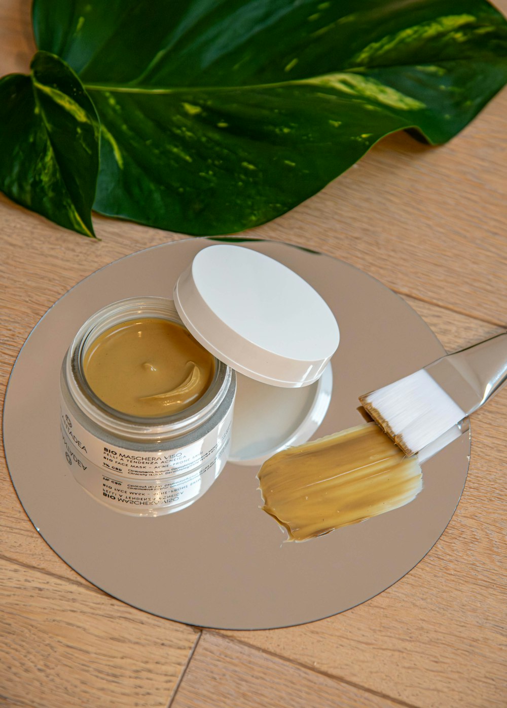 a jar of cream and a brush on a table