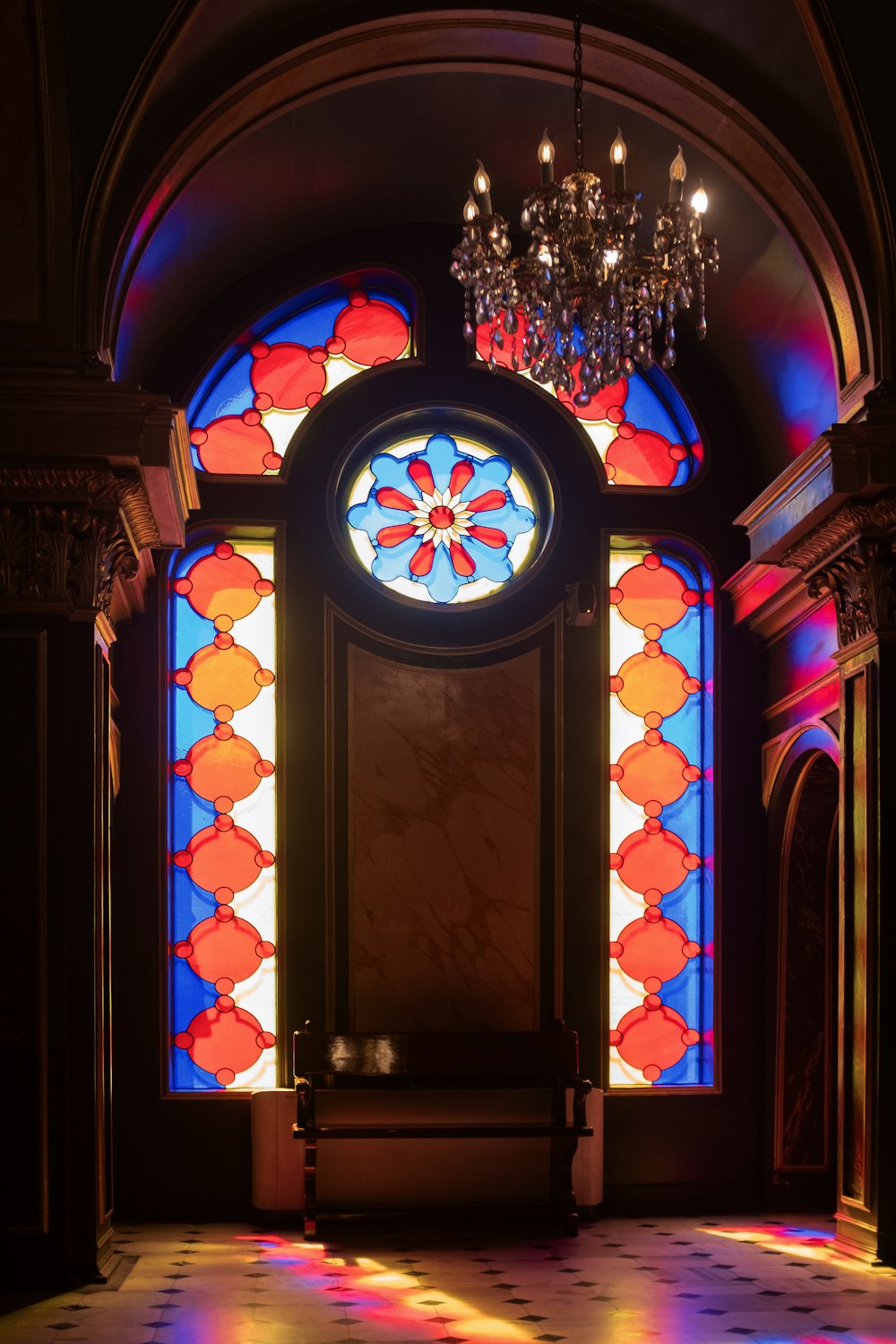 a stained glass window with a chandelier hanging from it