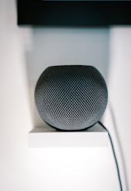 an apple home speaker sitting on top of a white shelf