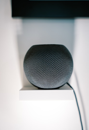 an apple home speaker sitting on top of a white shelf