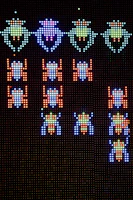 Close-up of a vibrant arcade game t-shirt featuring pixel art characters.