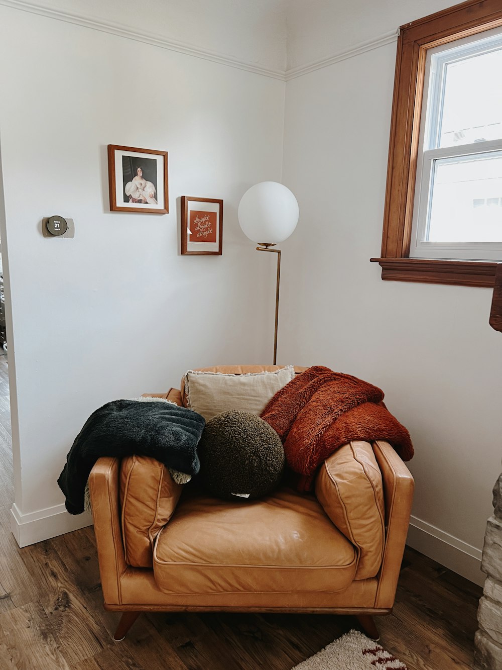 a brown leather chair with pillows on top of it