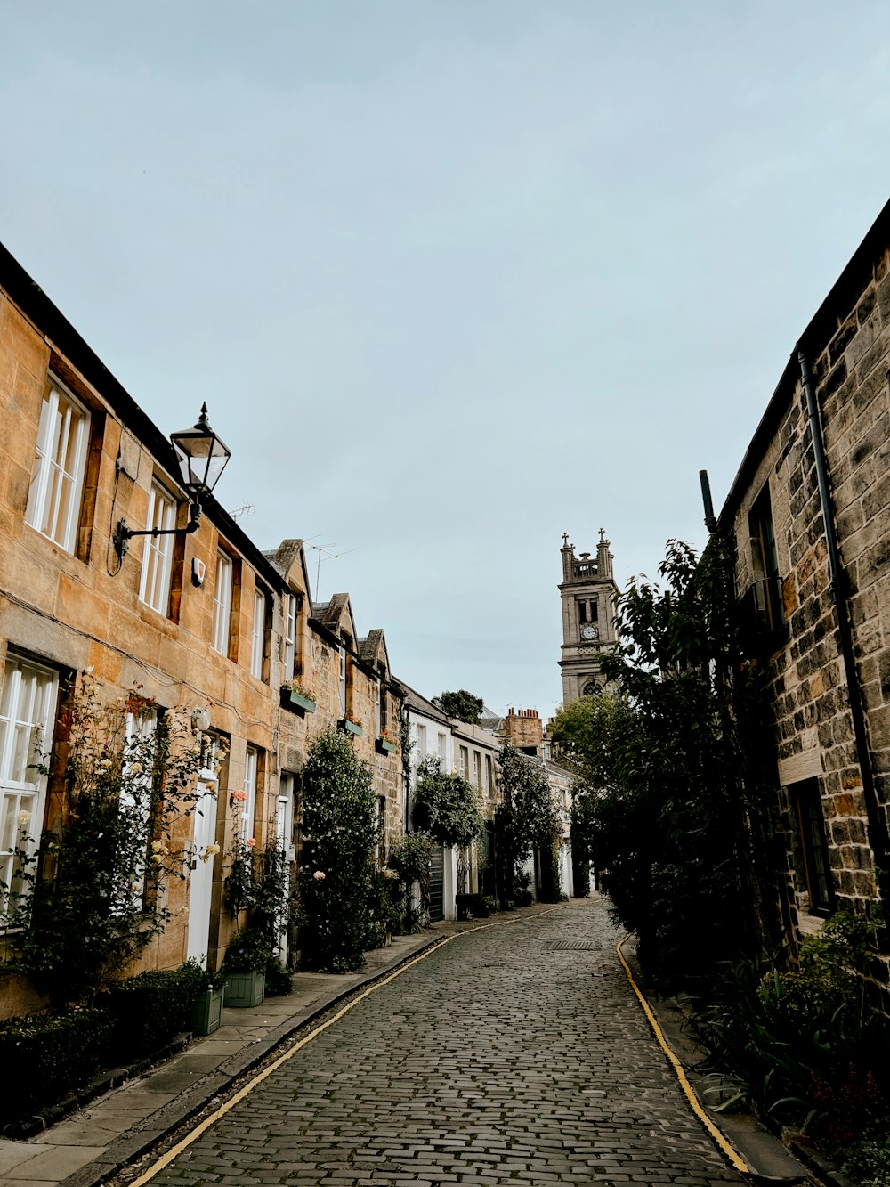 a cobblestone street with a clock tower in the background