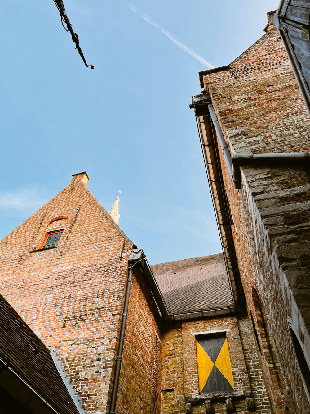 a tall brick building with a yellow and black flag on it's side