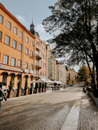 Historic city street lined with colorful buildings and cobblestone pavement.