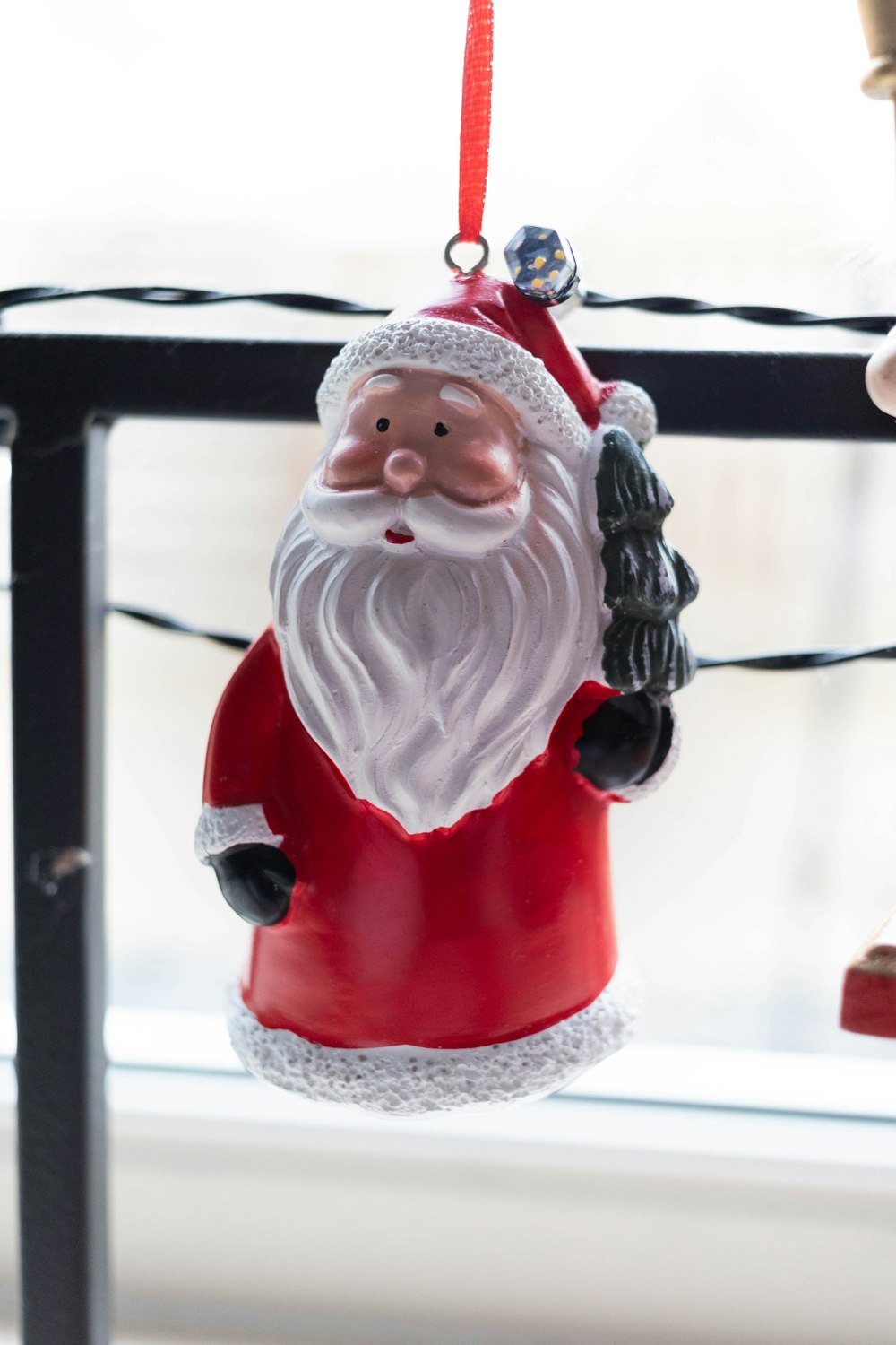 a santa clause ornament hanging from a christmas tree