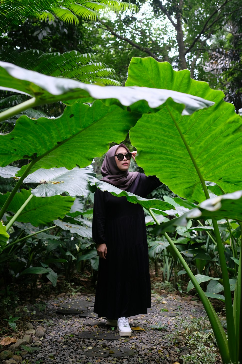 Una donna che indossa un hijab in piedi nel mezzo di una giungla