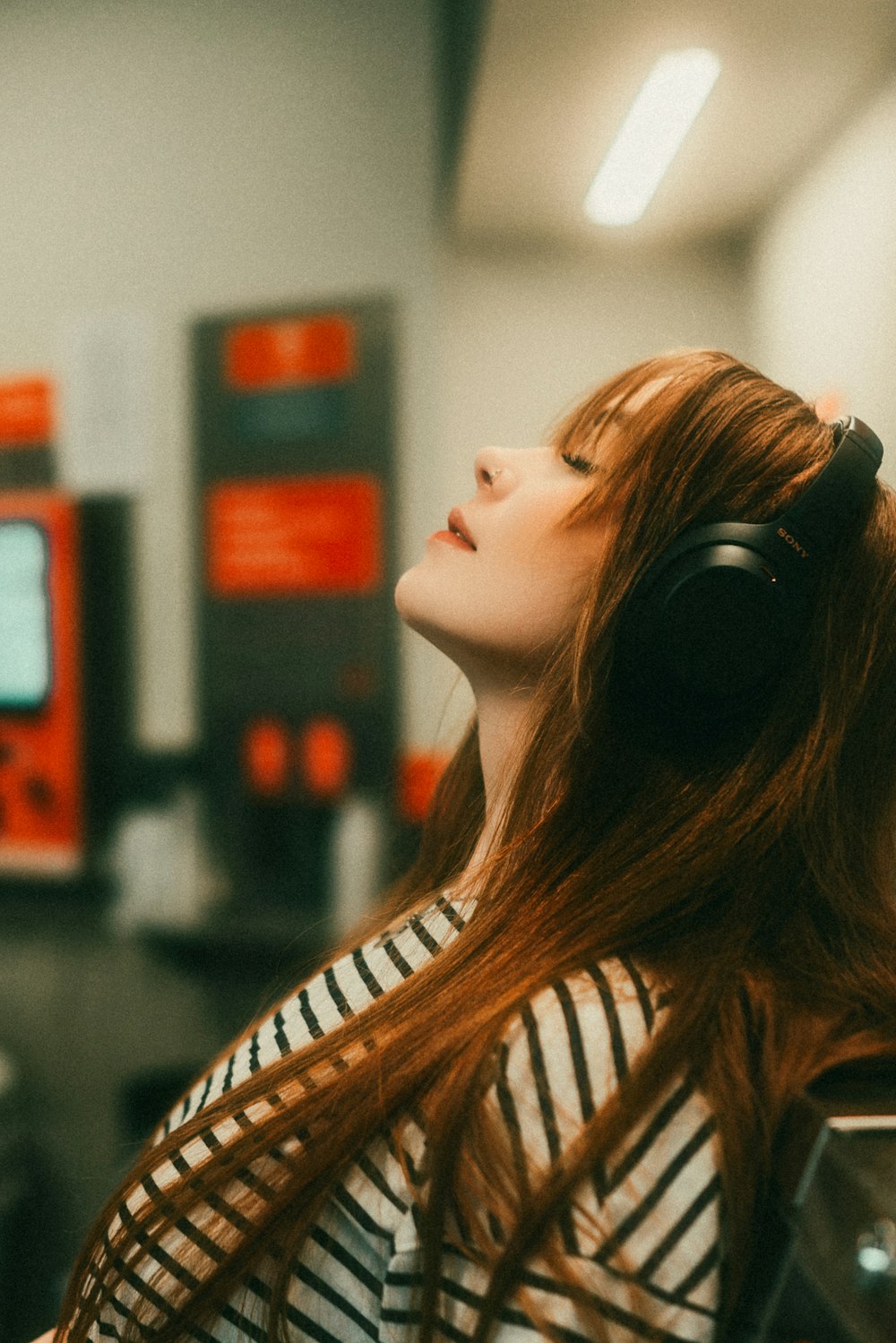 a woman with long red hair wearing headphones