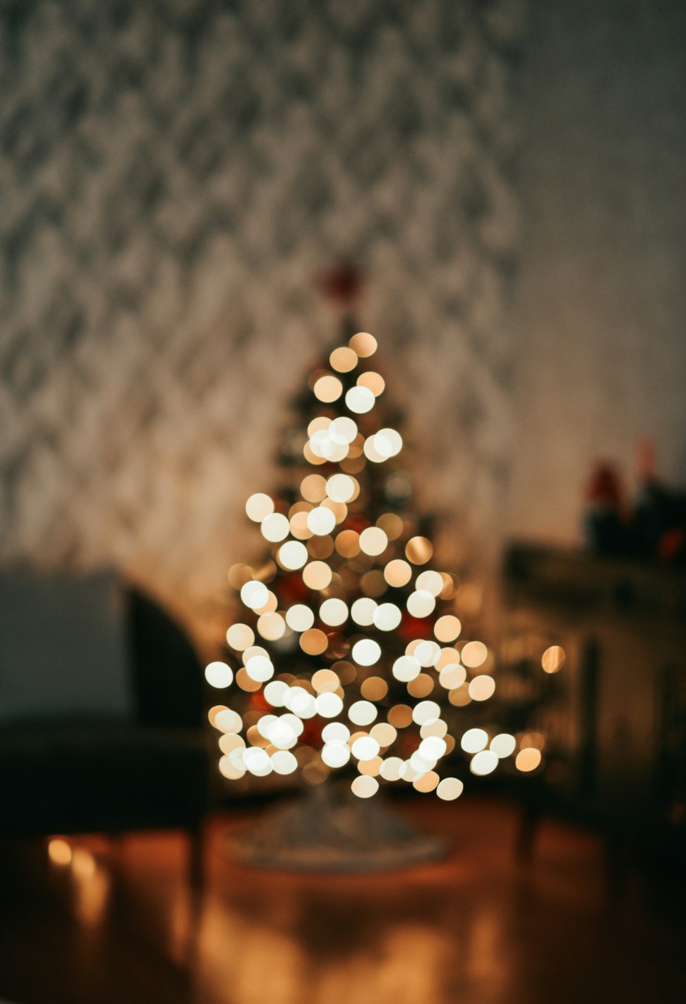 a lit christmas tree sitting on top of a wooden table