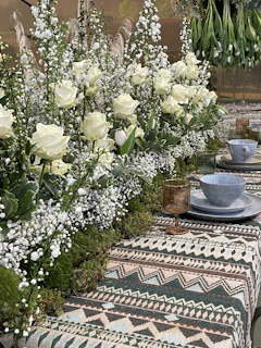 A playful tablescape featuring bold ceramics and fresh blooms, styled with a feminine, modern touch