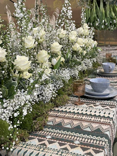 A playful tablescape featuring bold ceramics and fresh blooms, styled with a feminine, modern touch