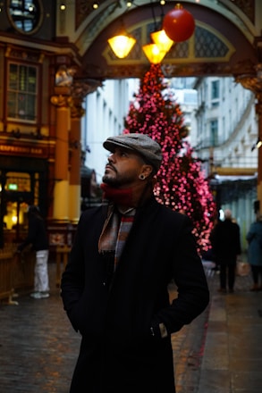 a man standing in front of a christmas tree