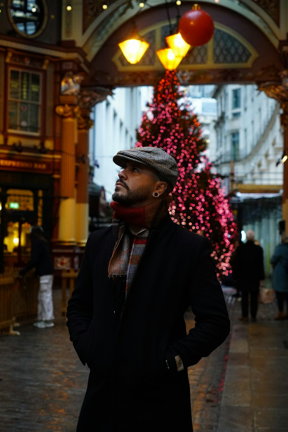 a man standing in front of a christmas tree