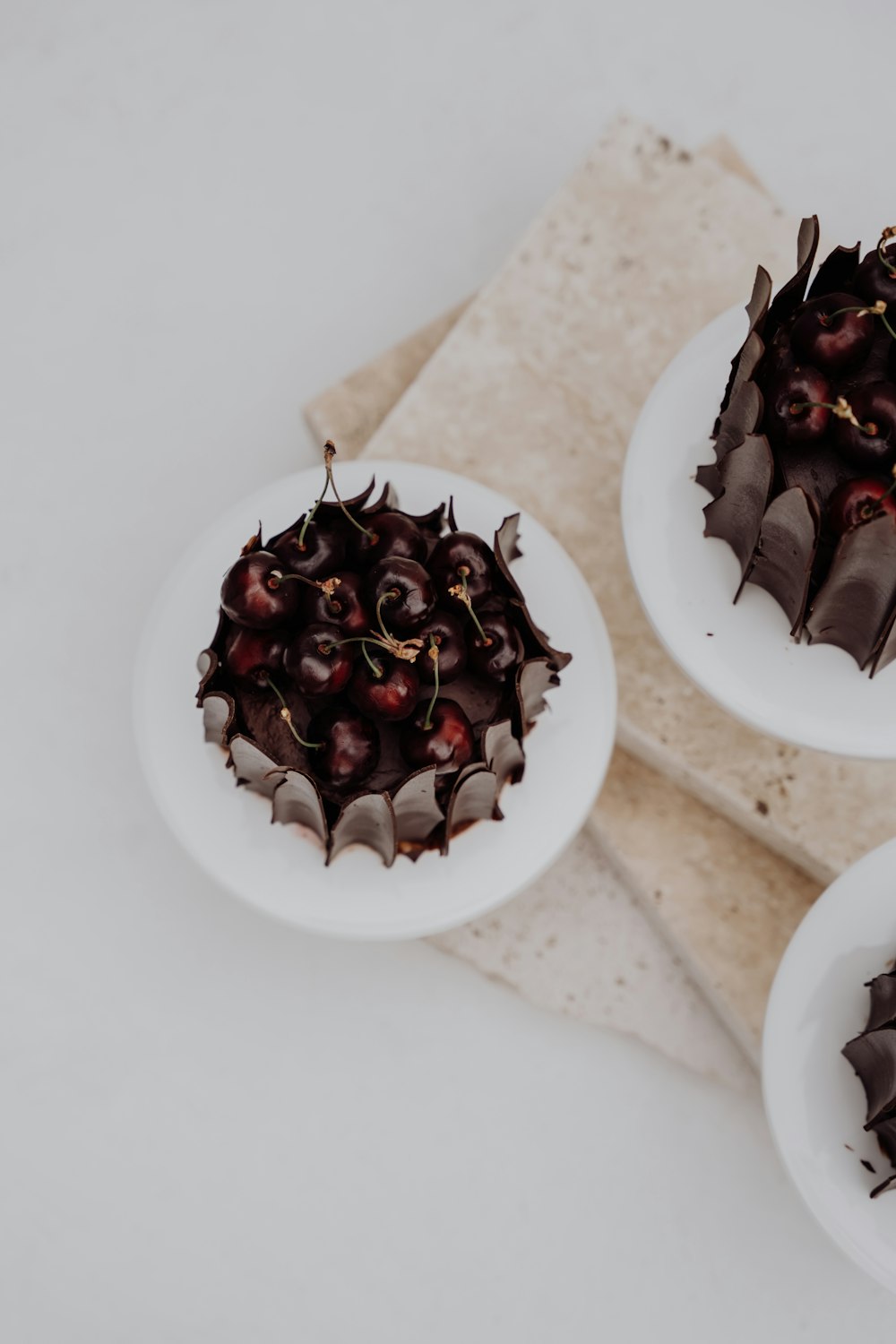 two white plates topped with chocolate cake on top of a table