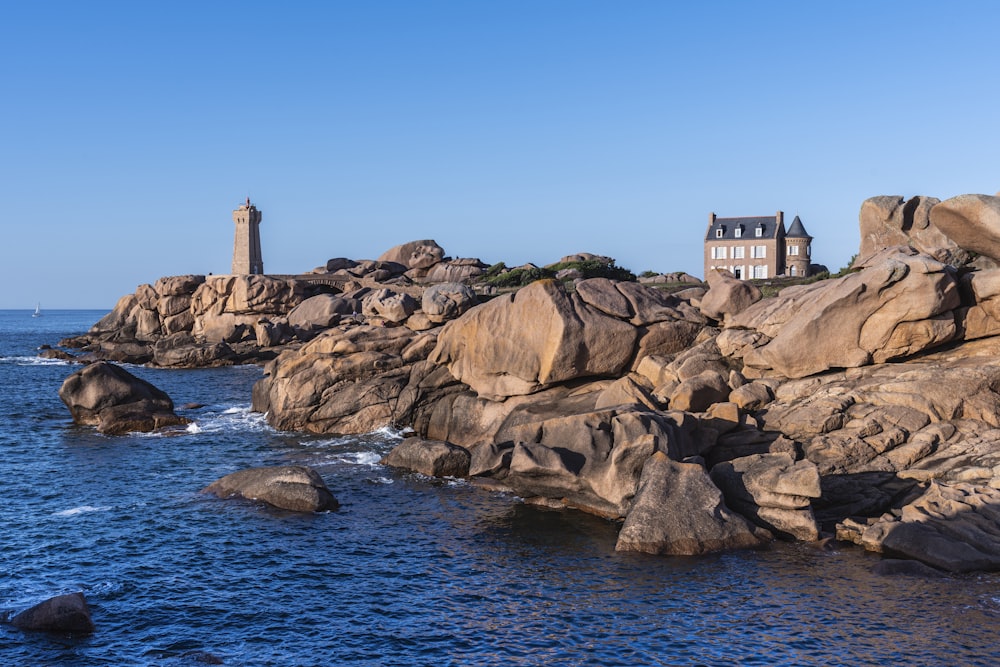 a house on top of a rock outcropping next to the ocean