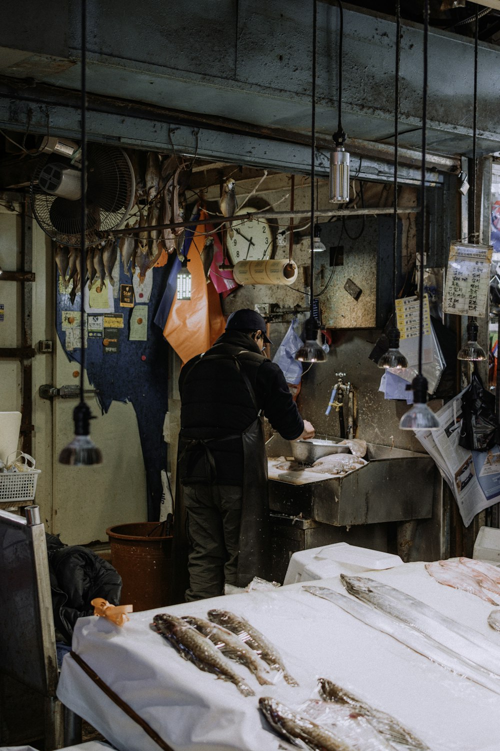 a man standing in a fish market next to a counter