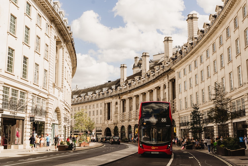 a red double decker bus driving down a street