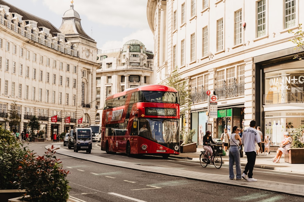 a red double decker bus driving down a street