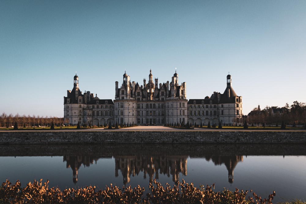 a large castle with a lake in front of it