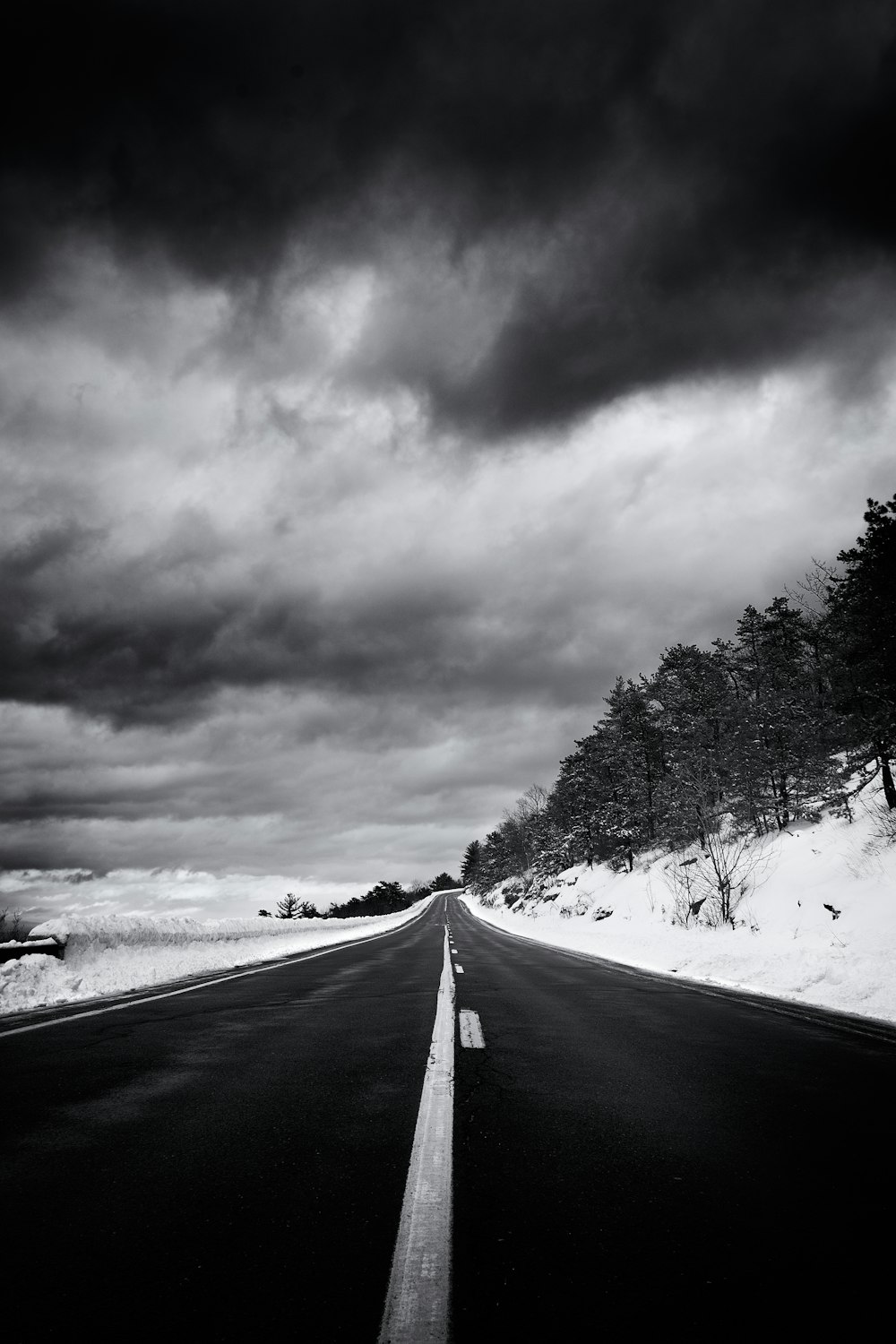 a black and white photo of a snowy road