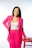 a woman in a bright pink suit posing for a picture