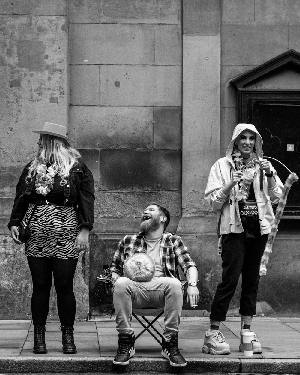 a man sitting in a chair next to two women