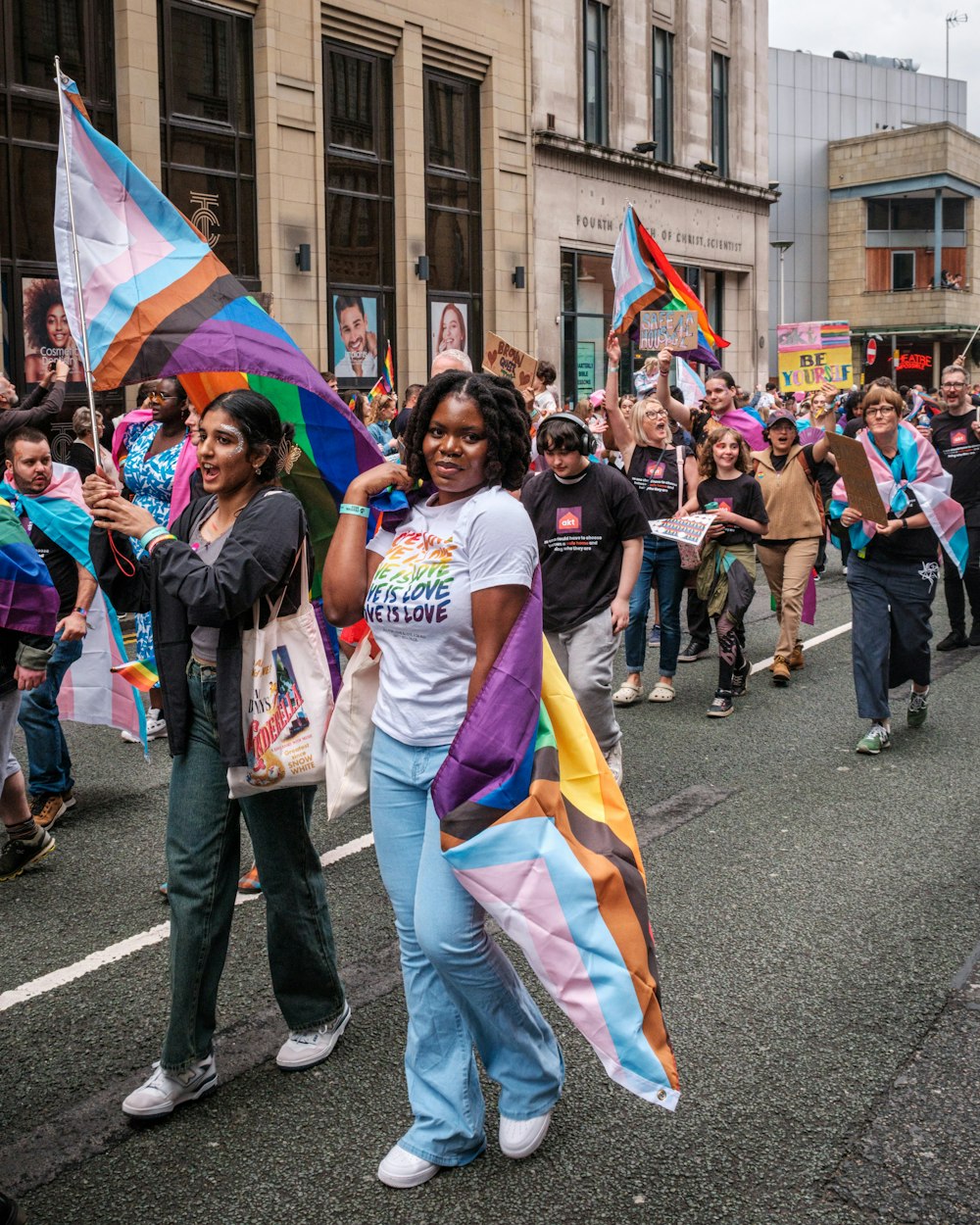 a group of people walking down a street holding flags