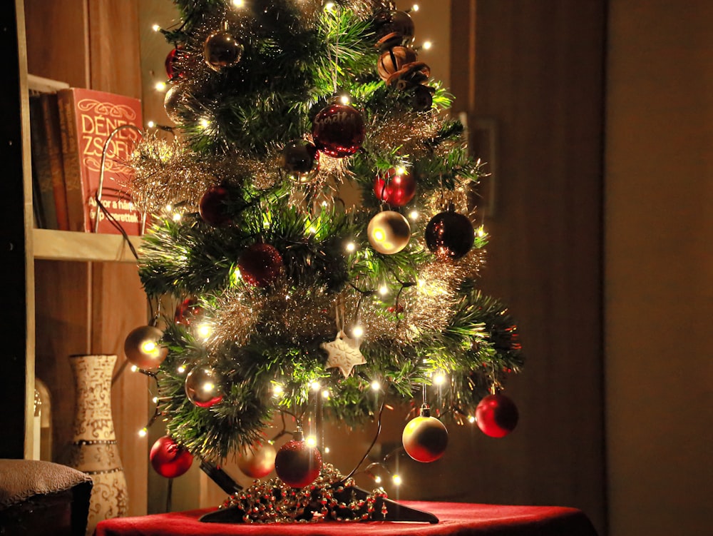 a small christmas tree with lights and ornaments
