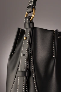 Artisan hand sewing a leather strap, emphasizing traditional hand-stitching techniques.