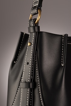 a black handbag with a gold handle